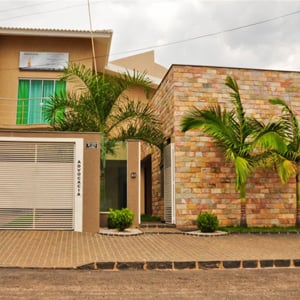 As altas palmeiras na frente da parede de pedras compõe o cenário do escritório de Pontalina/GO.