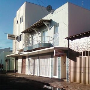 No sobrado de tonalidade clara detalhado com pastilhas azuis está instalado um escritório da populosa Uberlândia/MG. Na parte superior, as duas sacadas permitem aos advogados conferirem o movimento da rua.