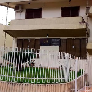 A fachada da banca de Cambé/PR combina cores neutras com o verde do projeto de paisagismo.
