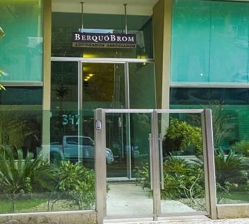 As vidraças do escritório deixam aparente o belo jardim na entrada da banca de Goiânia/GO.