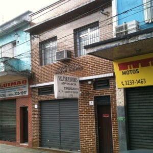 No centro da portuária Santos/SP, o sobrado de tijolos à vista abriga o escritório de advocacia. 