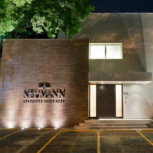 Os tons amadeirados e a vegetação no entorno da residência marcam a fachada da banca de SP. 