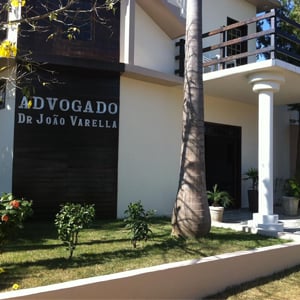 Com detalhes em madeira, o grande escritório de Matupá/MT se destaca pelo diversificado jardim : vários tipos de plantas e suas altas palmeiras.