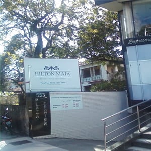 Ao fundo da placa da banca de João Pessoa/PB, uma gigante árvore emoldura o ambiente. 