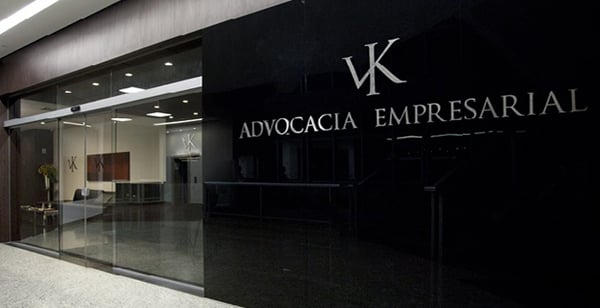 É possível notar, pela porta de vidro da fachada, o interior do elegante escritório de Belo Horizonte/MG.