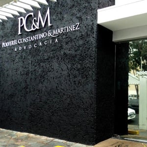 O nome do escritório de Ribeirão Preto/SP em letras prateadas se destaca na parede com texturas. 