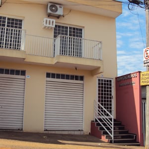 Letras prateadas se destacam no muro vermelho do sobrado do escritório de Votuporanga/SP. 