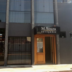 Na mineira Frutal, a porta de madeira do escritório sobressai em meio ao tom escuro do prédio. 