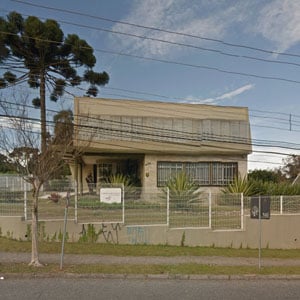 O límpido céu e a araucária emolduram a fachada do escritório de Curitiba/PR. 