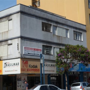 Da avenida movimentada no centro de Poços de Caldas/MG é possível notar em prédio comercial a placa do escritório de advocacia.