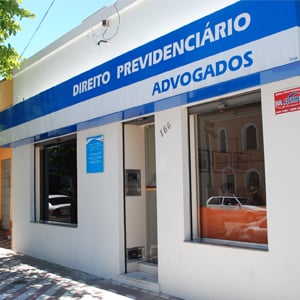 A frente do escritório de Pelotas/RS é sombreada por uma grande árvore. 