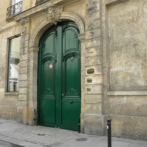 A suntuosa porta verde da banca de Paris/França é ornamentada com linhas que remetem à época antiga. 
