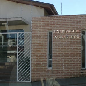 O nome do escritório de Franca/SP em letras metalizadas realça na parede de tijolos à vista. 