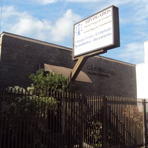 Atrás das grades, o jardim do escritório de José Bonifácio/SP é iluminado pelo sol. 