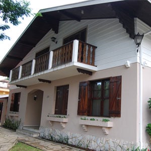 Abaixo das robustas janelas de madeira, floreiras decoram a fachada do escritório de Curitiba/PR. 