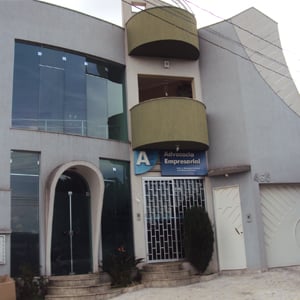 Abaixo de duas sacadas arredondadas, o escritório de Franca/SP se encontra no meio de duas altas paredes. 