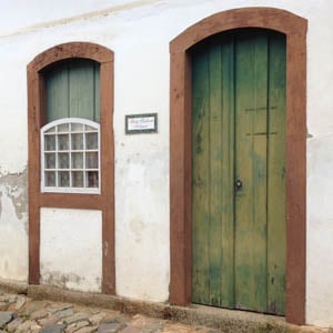 A rua calçada com pedras e o casarão onde está situado o escritório de Paraty/RJ, relembram o período colonial.