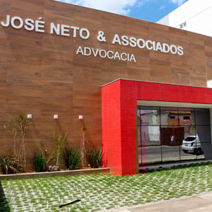 A diversidade de revestimentos - do estacionamento à fachada - realça o escritório baiano de Feira de Santana.