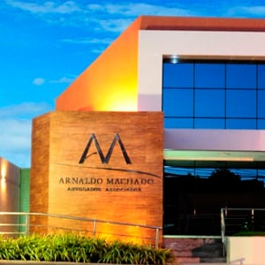 A modernidade, resultado dos vidros espelhados e do logotipo em parede amadeirada, destaca a fachada do escritório de Aracaju/SE. 