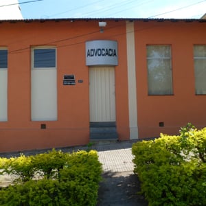 Um estreito caminho no meio de volumosas folhagens verdes leva o cliente até o escritório de parede alaranjada da turística Poços de Caldas/MG.