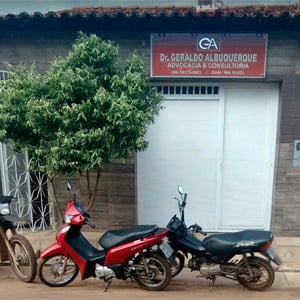 No fundo amadeirado, a porta branca e a placa realçam a fachada da banca de Bacabal/MA. 