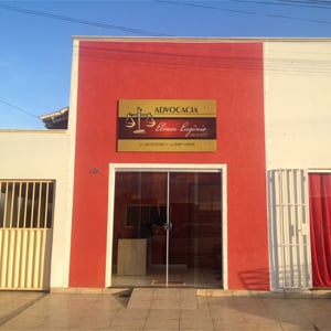 A placa dourada se destaca na parede vermelha do escritório de Gurupi/TO. 