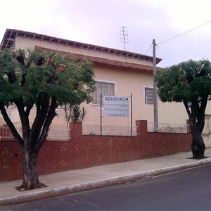 Árvores bem podadas emolduram a fachada do escritório de Pederneiras/SP. 