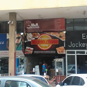 A placa do escritório se mistura aos letreiros das lojas do setor comercial sul de Brasília. 