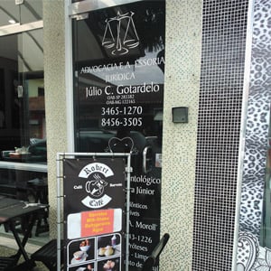 Em prédio empresarial na terra do tricô, Monte Sião/MG, os dados do escritório se destacam na porta de vidro fumê. 