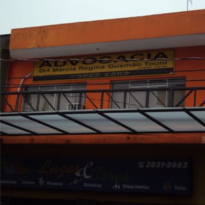 Lá no Vale do Ribeira, em Registro/SP, a fachada, meio escondida pela grade e pelos fios, chama atenção pela tonalidade forte que apresenta.