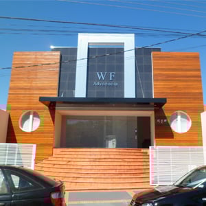 O revestimento de madeira nas paredes harmoniza com o piso de mesmo tom da escadaria do grande escritório de Tupã/SP.