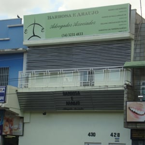 A banca de Uberlândia/MG localizada em sobrado de tom suave se destaca entre pontos comerciais movimentados. 