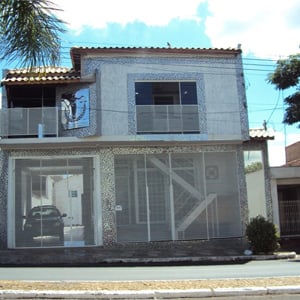 Na terra da cerâmica, Porto Ferreira/SP, grades horizontais protegem o escritório, que tem em sua fachada uma grande placa metalizada da Deusa Thêmis. 