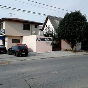 As letras garrafais em preto contrastam com a sobriedade do prédio em cinza e marrom.