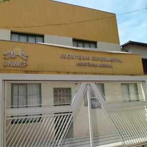 Em Lins/SP, o escritório experimental da UNIMEP é fechado por um alto e extenso portão de ferro gradeado.