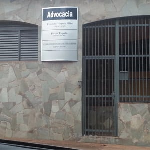 A placa metálica se destaca na parede de ardósia do escritório de Cravinhos/SP. 