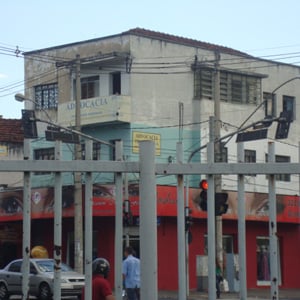 Através das grades é possível notar uma antiga construção que abriga o escritório de Uberlândia/MG.